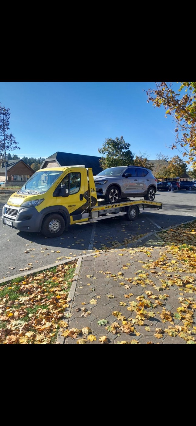 Majerić towing service — yellow tow truck with a loaded vehicle